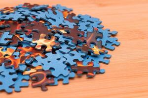 Colorful Pieces of a Mixed Jigsaw Puzzle Lie on the Wooden Table - Strategy and Solving Problem Concept photo
