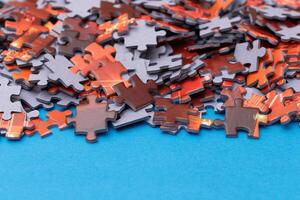 Mixed Pieces of a Colorful Jigsaw Puzzle Lie on the Blue Background - Strategy and Solving Problem Concept photo