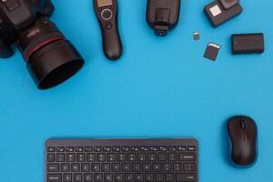 Top View of Photographer's, Videographer's or Blogger's Workplace. Digital Gadgets Lying on Blue Table - Flat Lay photo