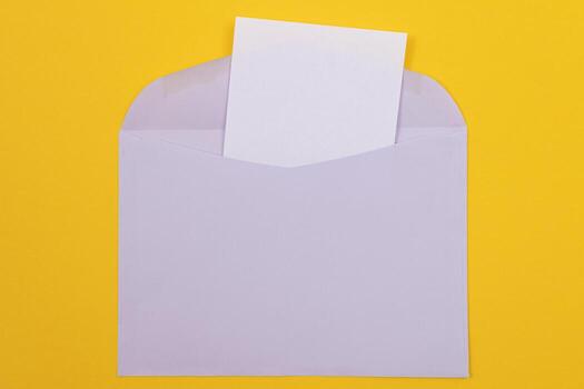 Violet Envelope with Blank White Sheet of Paper Inside, Lying on Yellow Background - Mock Up with Copy Space. Receiving Mail or Notice, Sending Postcard - Top View, Flat Lay photo