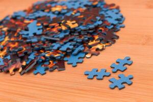 Colorful Pieces of a Mixed Jigsaw Puzzle Lie on the Wooden Table - Strategy and Solving Problem Concept photo