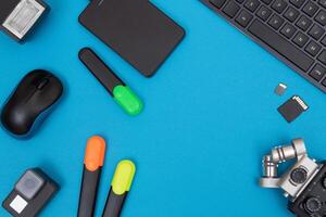 Top View of Photographer's, Videographer's or Blogger's Workplace. Digital Gadgets Lying on Blue Table - Flat Lay photo