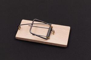 Wooden Mouse Trap. Empty Loaded Mousetrap on Black Background photo