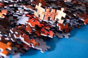 Mixed Pieces of a Colorful Jigsaw Puzzle Lie on the Blue Background - Strategy and Solving Problem Concept photo