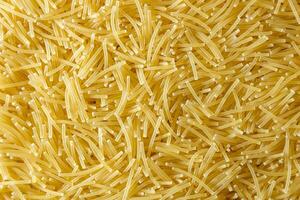 Uncooked Filini Pasta. A Culinary Canvas of Noodles, Creating a Lively and Textured Background for Gourmet Cooking. Dry Pasta. Raw Macaroni - Top View, Flat Lay photo