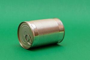 Unopened Tin Can with Blank Edge on Green Background. Canned Food. Aluminum Can for Safe and Long Term Storage of Food. Steel Sealed Food Storage Container photo