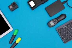 Top View of Photographer's, Videographer's or Blogger's Workplace. Digital Gadgets Lying on Blue Table - Flat Lay photo