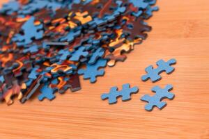Colorful Pieces of a Mixed Jigsaw Puzzle Lie on the Wooden Table - Strategy and Solving Problem Concept photo