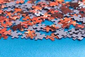 Mixed Pieces of a Colorful Jigsaw Puzzle Lie on the Blue Background - Strategy and Solving Problem Concept photo