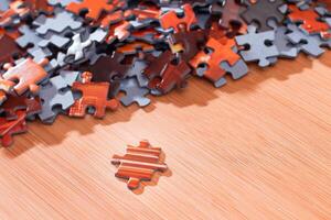 Colorful Pieces of a Mixed Jigsaw Puzzle Lie on the Wooden Table - Strategy and Solving Problem Concept photo