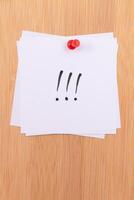 White Sticky Notes with Three Exclamation Points Pinned to the Wooden Message Board. To Do List Reminder in the Office. Memo Note at Work photo