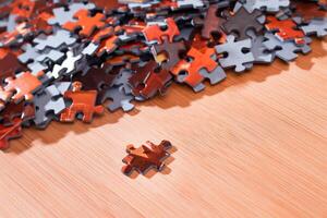 Colorful Pieces of a Mixed Jigsaw Puzzle Lie on the Wooden Table - Strategy and Solving Problem Concept photo