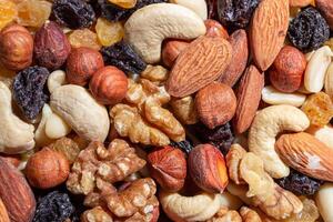 Mixed Nuts. Almonds, Walnuts, Cashews, Peanuts, Hazelnuts, Dried Prunes and Raisins. Different Nut Mix. Background from Various Nuts and Dried Fruits photo