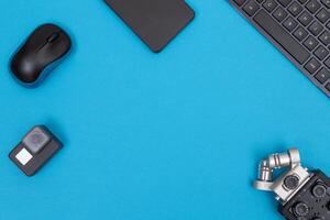 Top View of Photographer's, Videographer's or Blogger's Workplace. Digital Gadgets Lying on Blue Table - Flat Lay photo