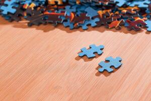Colorful Pieces of a Mixed Jigsaw Puzzle Lie on the Wooden Table - Strategy and Solving Problem Concept photo