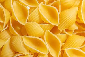 Uncooked Conchiglie Pasta. A Culinary Canvas of Conchiglie Macaroni, Creating a Lively and Textured Background for Gourmet Cooking. Dry Pasta. Raw Macaroni - Top View, Flat Lay photo