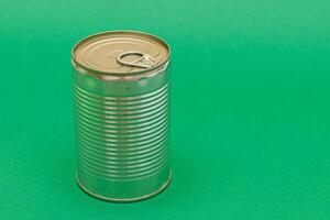 Unopened Tin Can with Blank Edge on Green Background. Canned Food. Aluminum Can for Safe and Long Term Storage of Food. Steel Sealed Food Storage Container photo