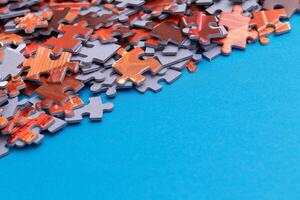 Mixed Pieces of a Colorful Jigsaw Puzzle Lie on the Blue Background With Copy Space - Strategy and Solving Problem Concept photo