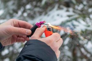 Guy Sets Fire to the Flash Noise Firecracker Outdoors in Winter at Daytime. Loud and Dangerous New Year's Entertainment. Hooliganism with Pyrotechnics. Noise of Petards in Public Places photo