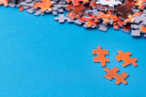 Mixed Pieces of a Colorful Jigsaw Puzzle Lie on the Blue Background With Copy Space - Strategy and Solving Problem Concept photo