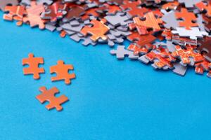 Mixed Pieces of a Colorful Jigsaw Puzzle Lie on the Blue Background - Strategy and Solving Problem Concept photo