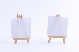 Two Wooden Easels Miniature with Blank White Square Canvas for Artists and Painters - Mockup. Mini Wooden Stand with Clean Artboard on White Background, Copy Space photo