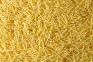 Uncooked Filini Pasta. A Culinary Canvas of Noodles, Creating a Lively and Textured Background for Gourmet Cooking. Dry Pasta. Raw Macaroni - Top View, Flat Lay photo