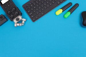 Top View of Photographer's, Videographer's or Blogger's Workplace. Digital Gadgets Lying on Blue Table - Flat Lay photo