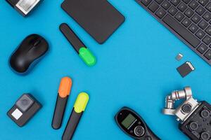 Top View of Photographer's, Videographer's or Blogger's Workplace. Digital Gadgets Lying on Blue Table - Flat Lay photo
