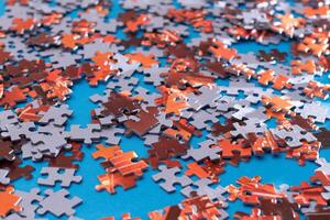 Mixed Pieces of a Colorful Jigsaw Puzzle Lie on the Blue Background - Strategy and Solving Problem Concept photo
