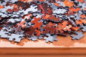 Colorful Pieces of a Mixed Jigsaw Puzzle Lie on the Wooden Table - Strategy and Solving Problem Concept photo