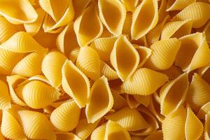 Uncooked Conchiglie Pasta. A Culinary Canvas of Conchiglie Macaroni, Creating a Lively and Textured Background for Gourmet Cooking. Dry Pasta. Raw Macaroni - Top View, Flat Lay photo