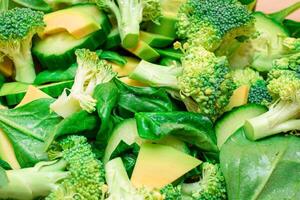 Fresh Green Salad of Avocado, Broccoli, Spinach and Cucumber for Body Detoxification - Close-Up. Vegan Salad. Vegetarian Culture. Raw Food. Healthy Eating and Vegetable Diet photo