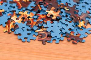 Colorful Pieces of a Mixed Jigsaw Puzzle Lie on the Wooden Table - Strategy and Solving Problem Concept photo
