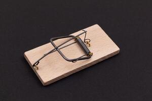 Wooden Mouse Trap. Empty Loaded Mousetrap on Black Background photo