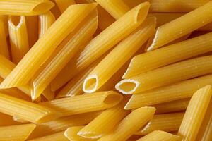 Uncooked Penne Rigate Pasta. A Culinary Canvas of Penne Macaroni, Creating a Lively and Textured Background for Gourmet Cooking. Dry Pasta. Raw Macaroni - Top View, Flat Lay photo