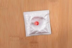 A Joke on Colleagues, Freebie or a Defective Condom - Packaged Latex Condom Pinned to a Wooden Message Board photo