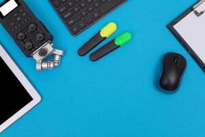Top View of Photographer's, Videographer's or Blogger's Workplace. Digital Gadgets Lying on Blue Table - Flat Lay photo