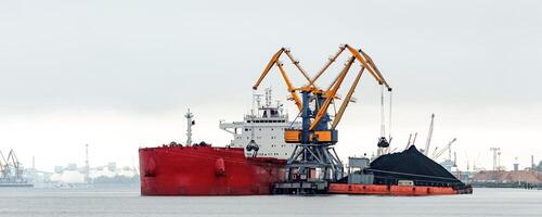 Large red cargo ship loading with a coal in the port photo