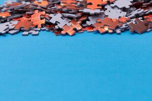 Mixed Pieces of a Colorful Jigsaw Puzzle Lie on the Blue Background With Copy Space - Strategy and Solving Problem Concept photo