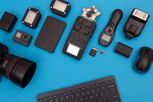 Top View of Photographer's, Videographer's or Blogger's Workplace. Digital Gadgets Lying on Blue Table - Flat Lay photo