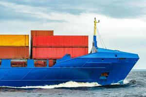 Blue cargo container ship fully loaded underway photo
