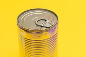 Unopened Tin Can with Blank Edge on Yellow Background. Canned Food. Aluminum Can for Safe and Long Term Storage of Food. Steel Sealed Food Storage Container photo