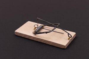 Wooden Mouse Trap. Empty Loaded Mousetrap on Black Background photo
