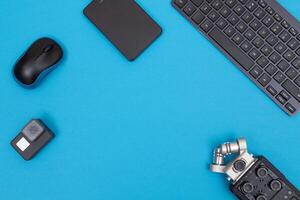 Top View of Photographer's, Videographer's or Blogger's Workplace. Digital Gadgets Lying on Blue Table - Flat Lay photo
