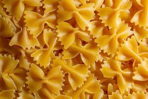 Uncooked Farfalle Pasta. A Culinary Canvas of Bow-Tie Macaroni, Creating a Lively and Textured Background for Gourmet Cooking. Dry Pasta. Raw Macaroni - Top View, Flat Lay photo