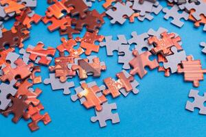 Mixed Pieces of a Colorful Jigsaw Puzzle Lie on the Blue Background - Strategy and Solving Problem Concept photo