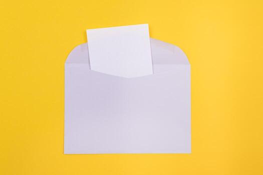 Violet Envelope with Blank White Sheet of Paper Inside, Lying on Yellow Background - Mock Up with Copy Space. Receiving Mail or Notice, Sending Postcard - Top View, Flat Lay photo