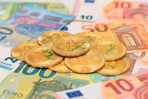 A Heap of Bitcoin Coins on the Euro Banknotes. Money Saving, Cryptocurrency, Blockchain and Anonymous Payments Concept photo