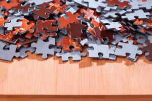 Colorful Pieces of a Mixed Jigsaw Puzzle Lie on the Wooden Table - Strategy and Solving Problem Concept photo